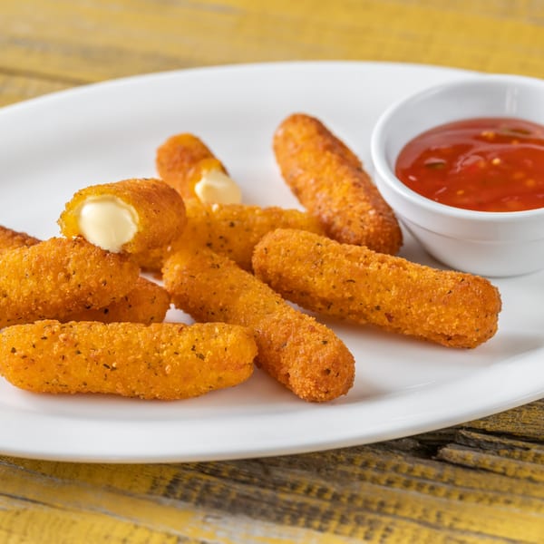 Golden-brown mozzarella sticks with a side of red dipping sauce on a white plate.